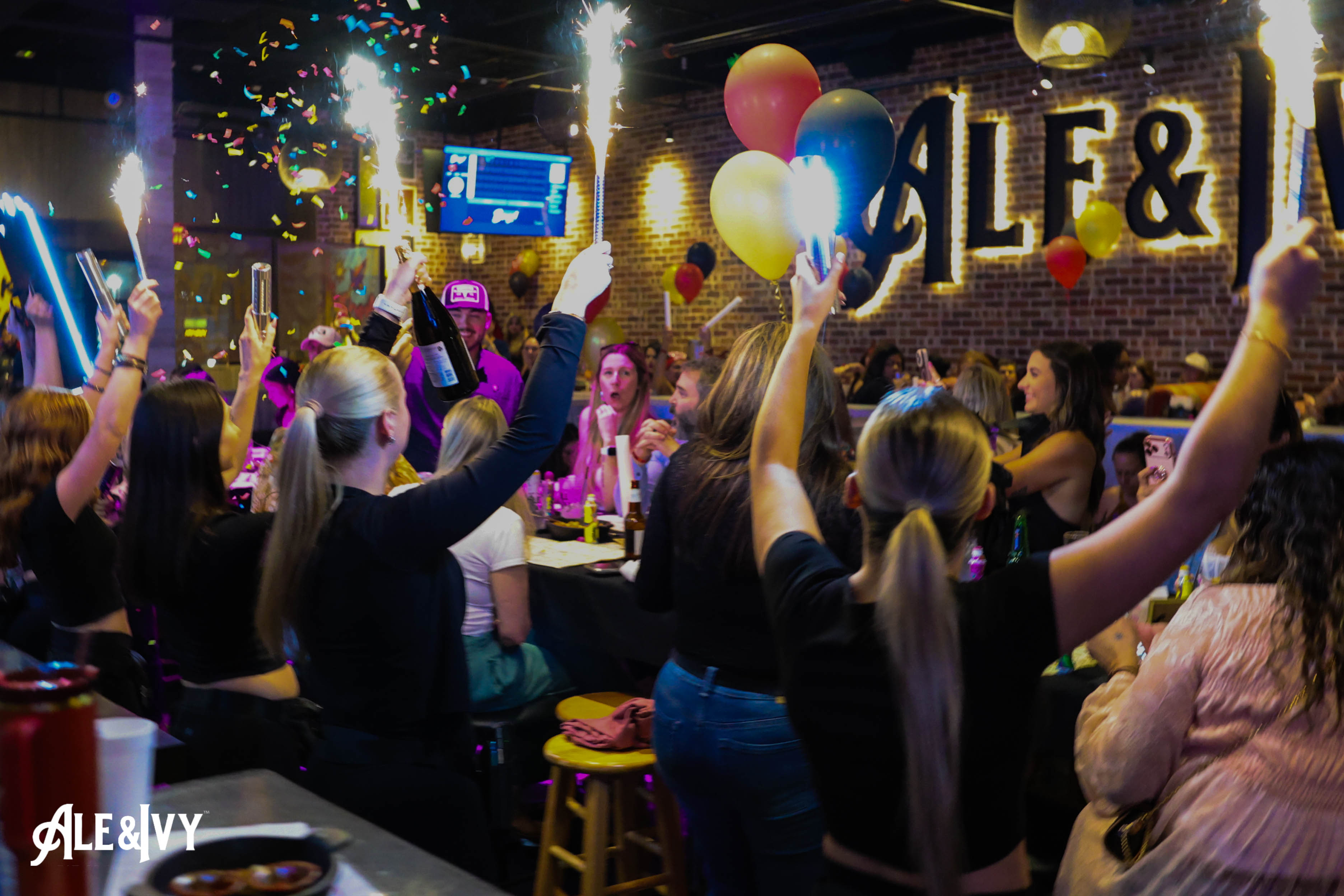 A packed Ale & Ivy event celebrating under confetti