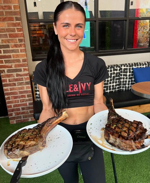 Ale & Ivy team member holding Tomahawk Tuesday steaks